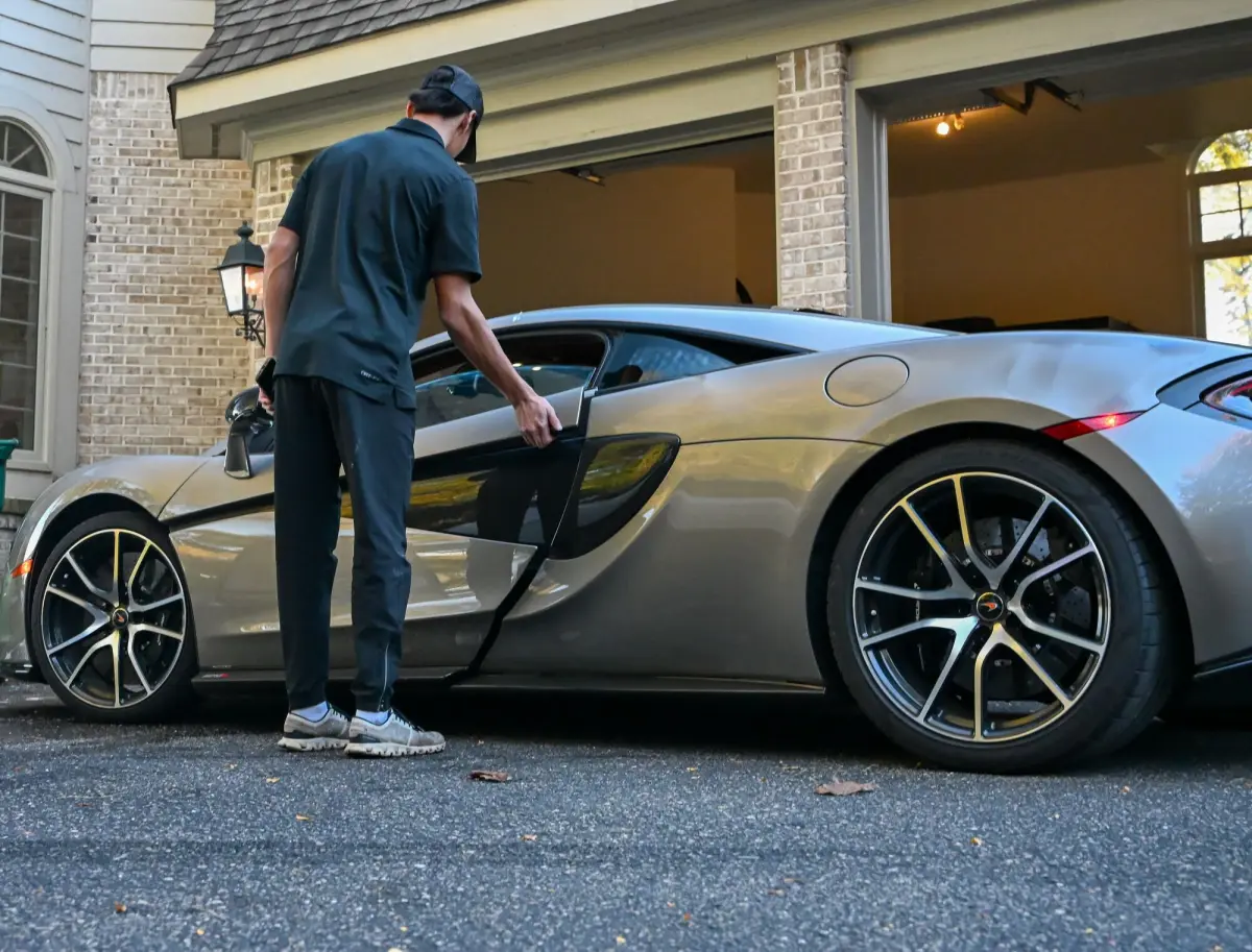 Nick opening the driver door of the McLaren in the driveway