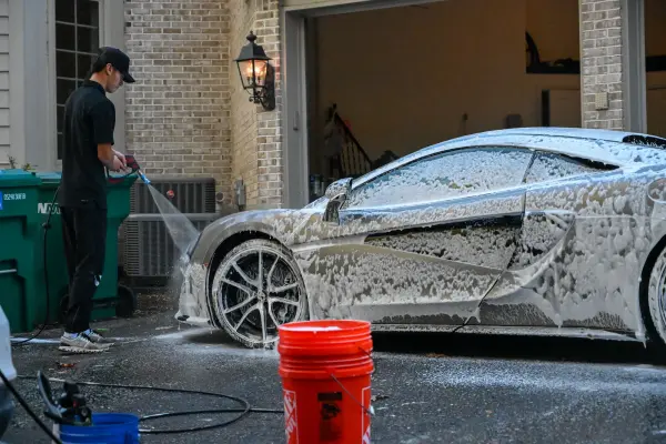 McLaren covered in foam in front of the garage